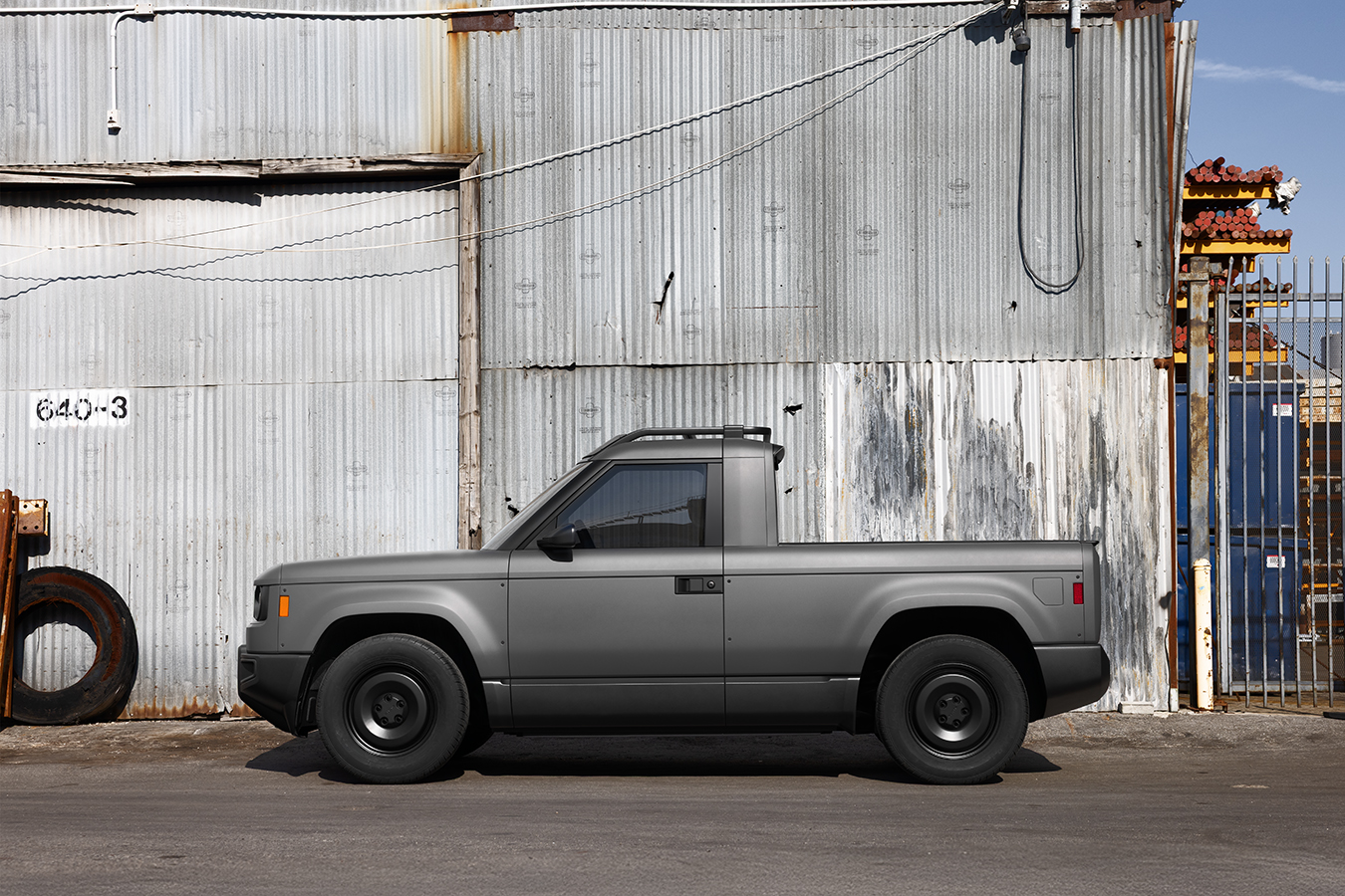 Blank Slate EV pickup truck parked in front of an industrial building